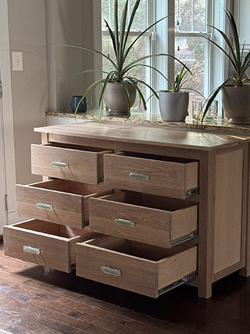 Six-drawer cerused white oak dresser with all drawers pulled open, showing the joinery and depth